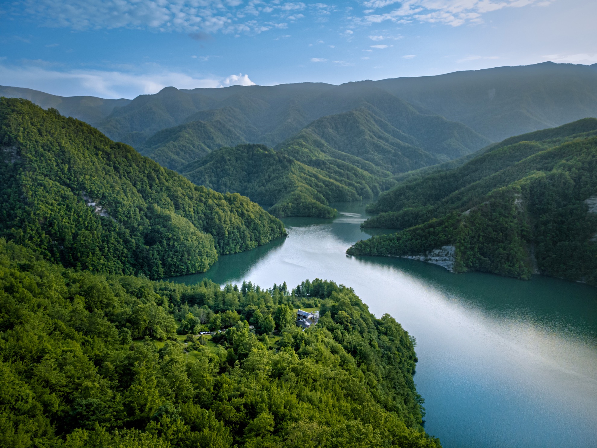 Il lago che serpeggia tra i boschi, visto dall'alto