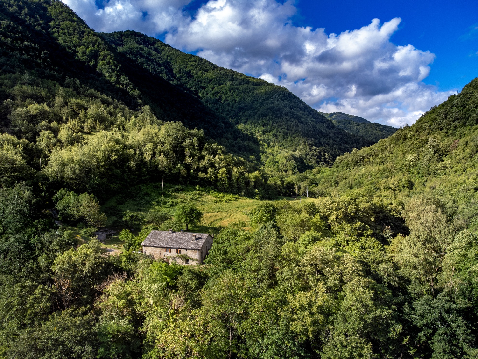 Il casale nella valle visto dall'alto, tra i boschi