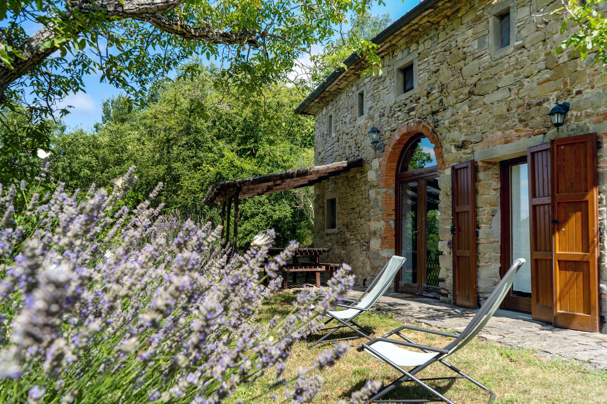 La casa in pietra tra la lavanda, con porte e finestre in legno