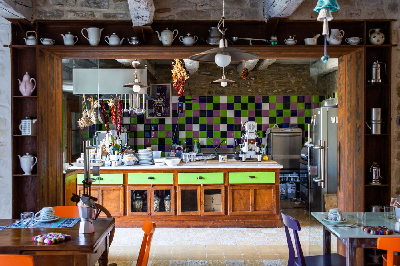 La sala con la cucina a vista e le tazzine sulla mensola