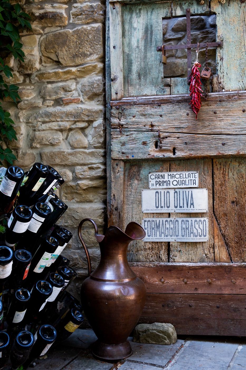 Porta in legno e pietra con le bottiglie in cantina