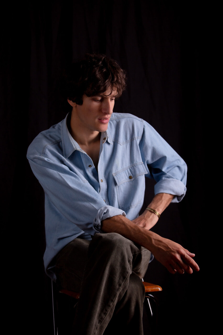 Ritratto maschile con camicia denim, seduto