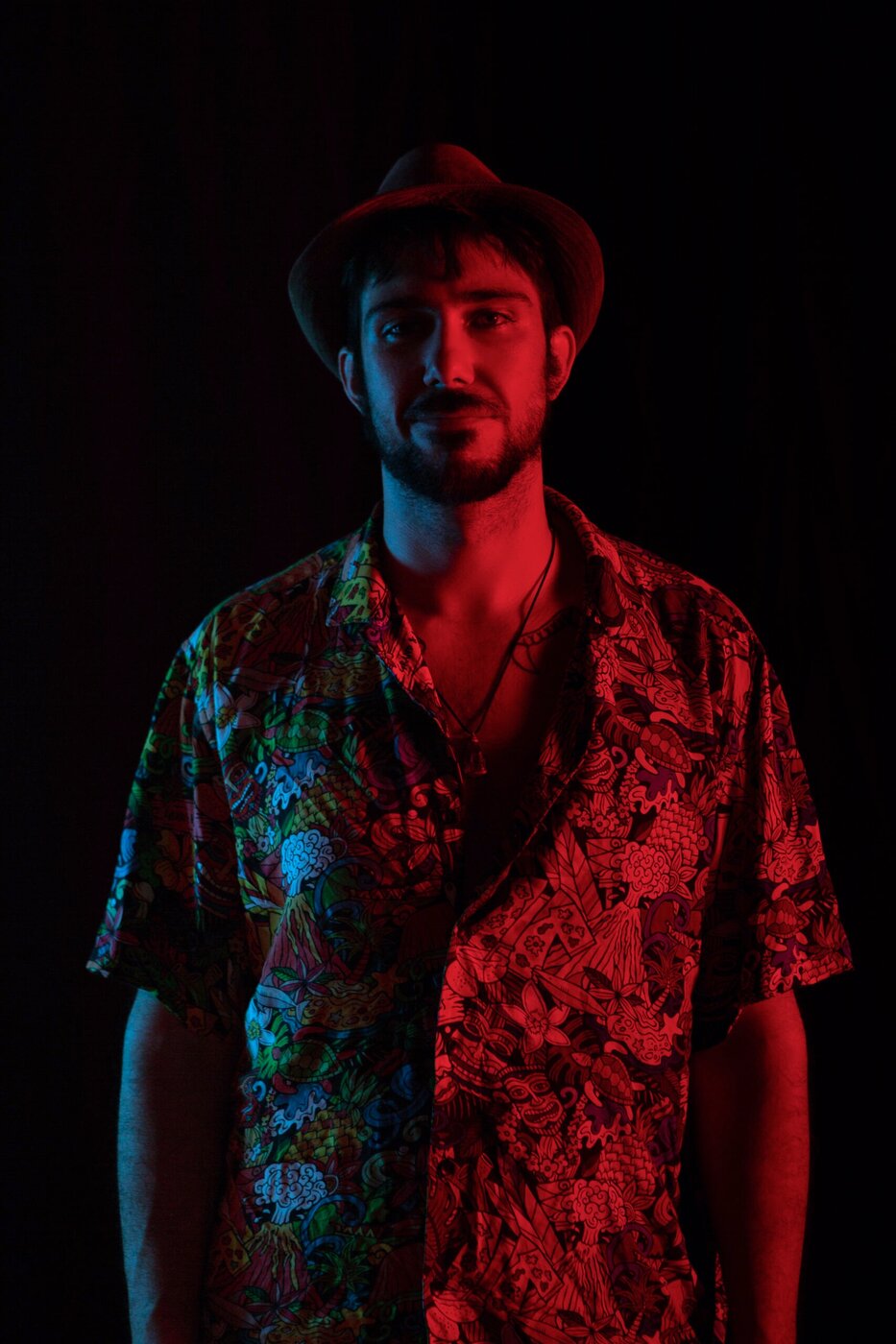 Ritratto maschile con cappello e luce bicolore rossa e blu