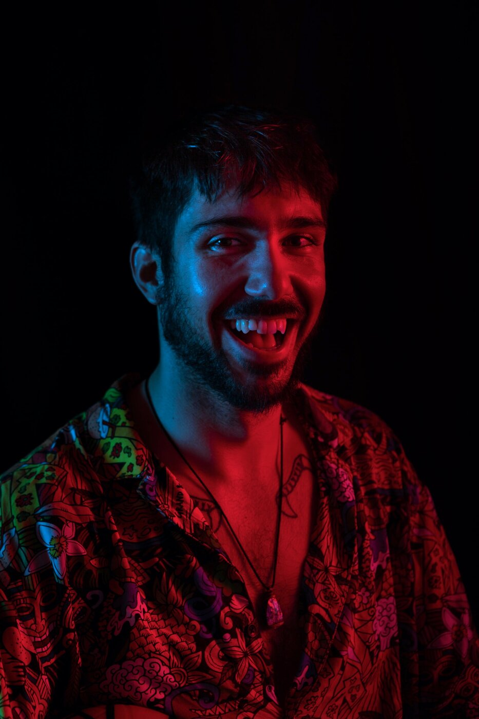 Ritratto maschile che ride, luce bicolore rossa e blu