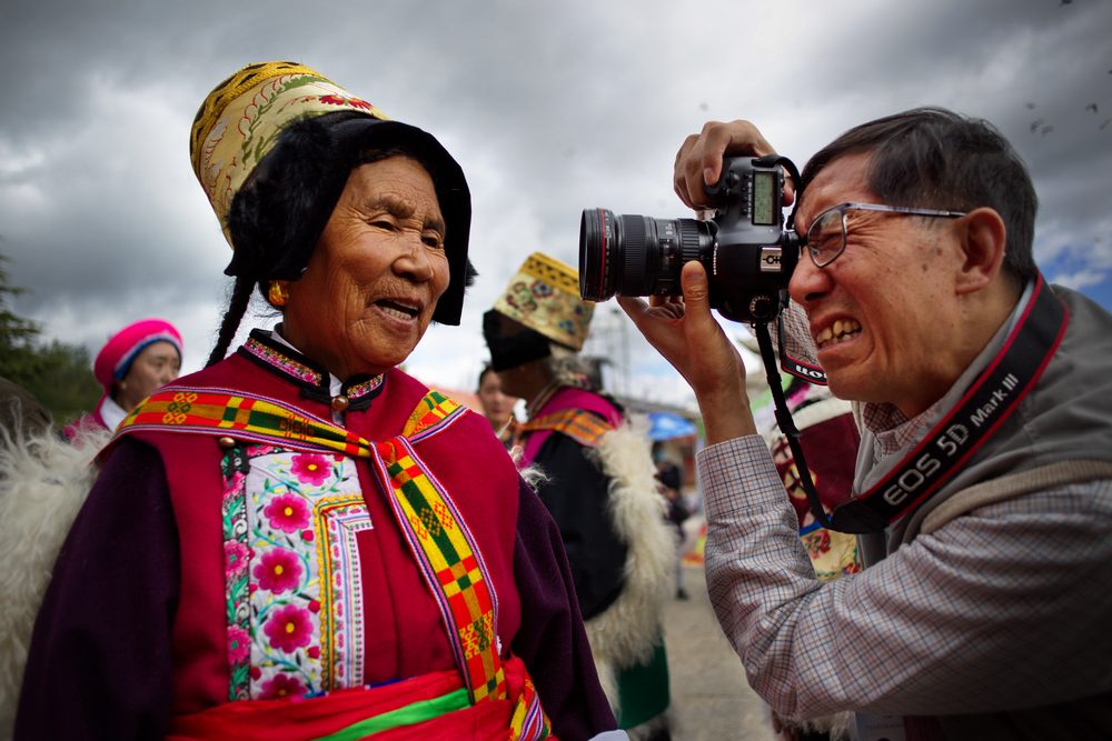 Turista fotografa una donna in abito tradizionale