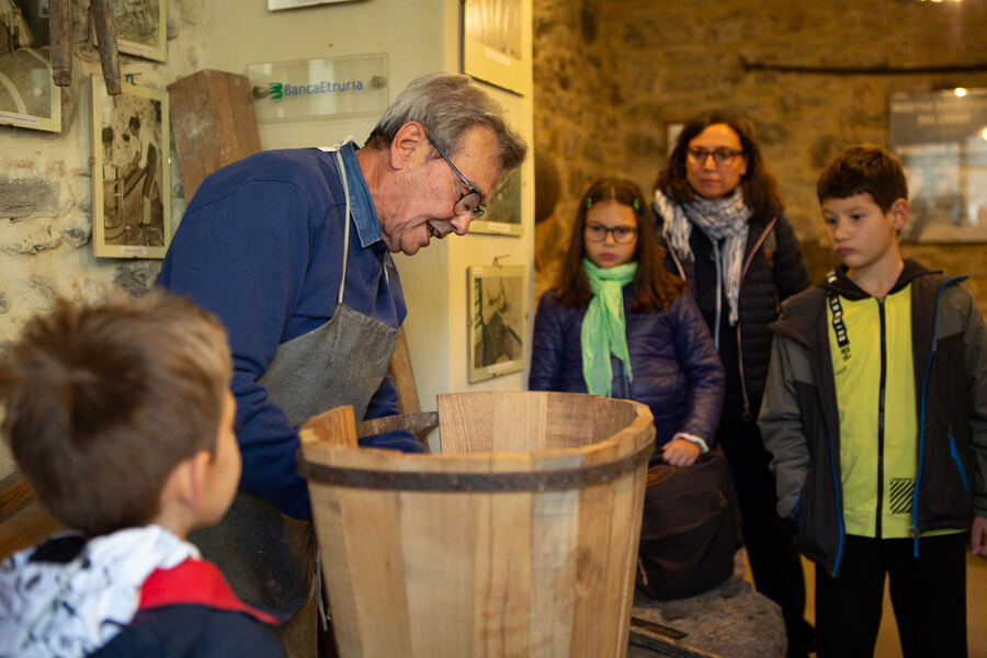 L'artigiano mostra un bigone in lavorazione ai bambini in visita